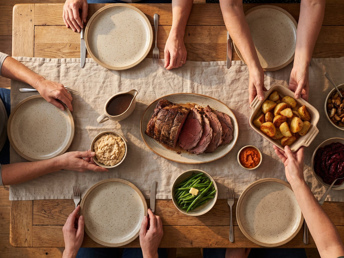 A carved Sunday roast with potatoes and gravy, plates passed around the table