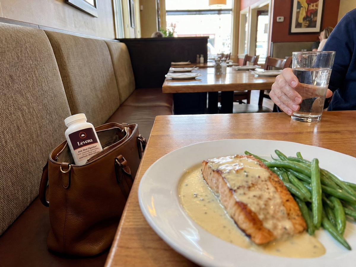 Salmon in cream sauce at a restaurant, the Levena bottle in a handbag