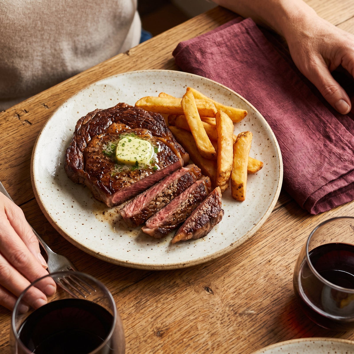 A sliced ribeye with butter and fries
